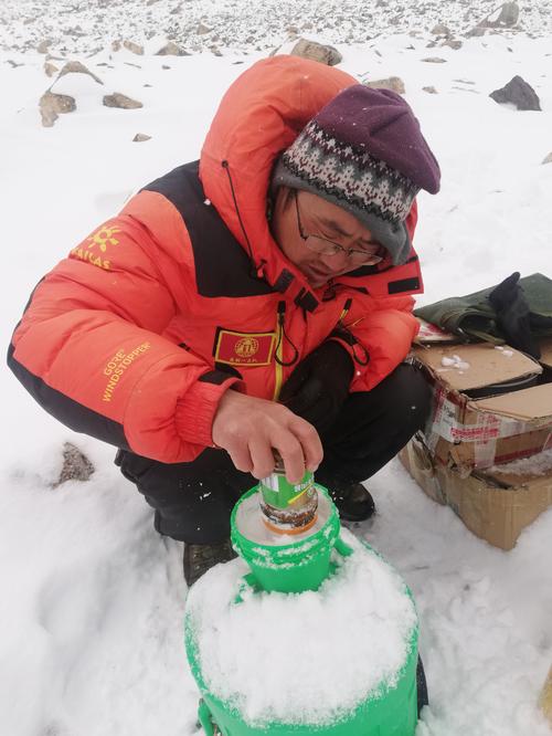 队员宋兆斌在海拔5500米中绒交会测量点进行存雪,以解决生活饮水.